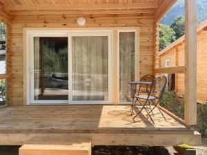 a wooden cabin with a table and chairs on the porch at Camping Piccolo Paradiso in Avegno