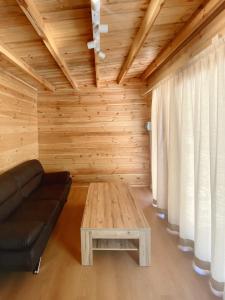 a living room with a black couch and a table at Camping Piccolo Paradiso in Avegno