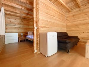 a living room with a refrigerator and a couch at Camping Piccolo Paradiso in Avegno
