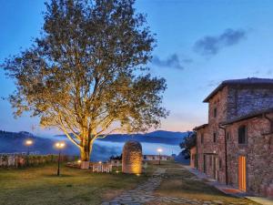 Vaglia的住宿－Agri Resort & SPA Le Colline del Paradiso，树在建筑物前的树