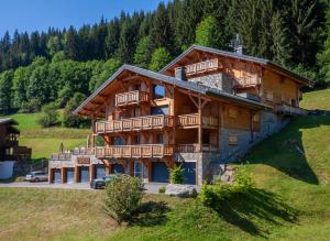 uma grande casa de madeira com varandas numa colina em ALTAKA 5 em Morzine