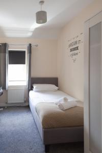 a bedroom with two beds and a sign on the wall at Mayflower Coach House by RentMyHouse in Hereford
