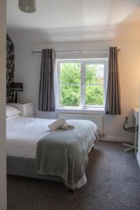 a bedroom with a bed and a window at Mayflower Coach House by RentMyHouse in Hereford