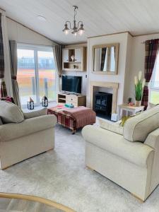Una sala de estar con dos sofás y un televisor. en Bude Holiday Resort, en Bude
