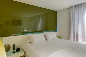 1 dormitorio con cama blanca y espejo en Apple Motel ( Adults Only ), en São Paulo