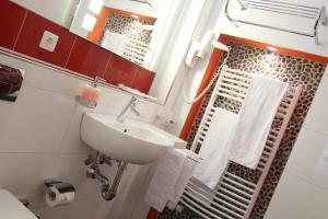 a bathroom with a sink and a mirror and towels at Ambiente Hotel Freieck in Chur