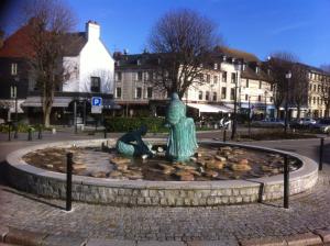 a statue of two women sitting in a fountain at Les Charmettes in Honfleur