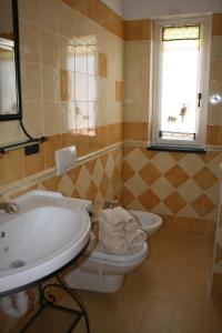 een badkamer met een wastafel, een toilet en een raam bij L'Allegra Brigata in Finale Ligure