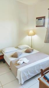 ein Hotelzimmer mit zwei Betten mit Handtüchern darauf in der Unterkunft Hotel São Paulo Inn in Santa Rita do Passa Quatro
