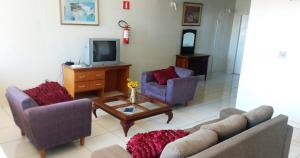 a living room with two couches and a tv at Hotel São Paulo Inn in Santa Rita do Passa Quatro
