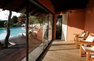 een glazen uitbreiding naar een huis met een zwembad bij Il Sole Di Ranco in Ranco