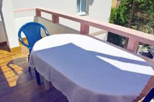 a table with a white table cloth on a balcony at Apartmani Vidušin in Novalja