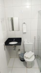 a white bathroom with a toilet and a sink at Hotel São Paulo Inn in Santa Rita do Passa Quatro