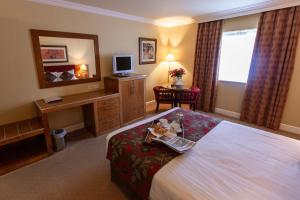 una camera d'albergo con un letto e una scrivania di Hamlet Court Hotel a Enfield