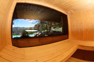 a round window in a wooden sauna at Il Sole Di Ranco in Ranco +23 photos