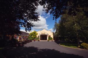 un vialetto che conduce a un edificio bianco con una grande porta di Hamlet Court Hotel a Enfield