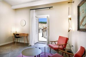 uma sala de estar com uma mesa e cadeiras e uma janela em A.D. 1768 Boutique Hotel em Ragusa