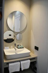 y baño con lavabo y espejo. en Hostal Sevilla Santa Justa - Adults only en Sevilla