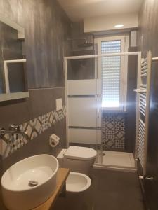 uma casa de banho com um lavatório branco e um WC. em MAGIA DI MARE em La Spezia
