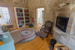a living room with a stone wall with a fireplace at Casa d' Avó Marcelina - Casas de Campo in Arcos de Valdevez