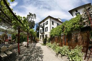 a courtyard with a white building and some plants at Il Sole Di Ranco in Ranco