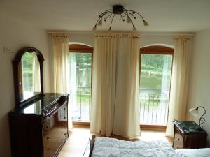 Ferienwohnungen am Büchlhof im Oberpfälzer Seenland في نينبورغ فورم والد: غرفة نوم بسرير وبيانو ونوافذ