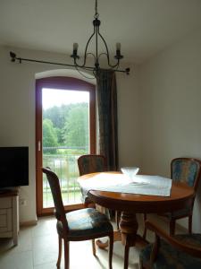 Ferienwohnungen am Büchlhof im Oberpfälzer Seenland في نينبورغ فورم والد: غرفة طعام بها طاولة وكراسي ونافذة