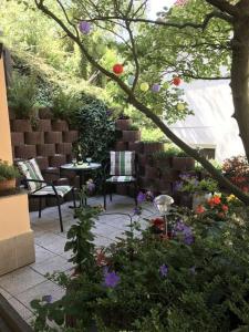 Pension Am Weinberg في ميسين: حديقة بها طاولة وكراسي وزهور