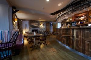 a restaurant with tables and chairs and a bar at The Pilsley Inn at Chatsworth in Baslow