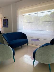 a living room with a blue couch and a window at Hotel La Meridiana in Sorrento