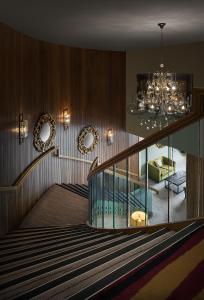 a staircase with a chandelier and a living room at Westville Hotel in Enniskillen