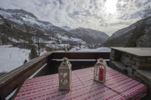 a table with two candles on a balcony with mountains at Hotel Rascard in Valtournenche