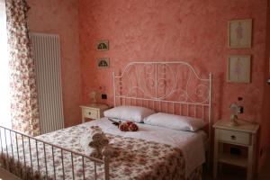 een slaapkamer met een wit bed en roze muren bij L'Allegra Brigata in Finale Ligure