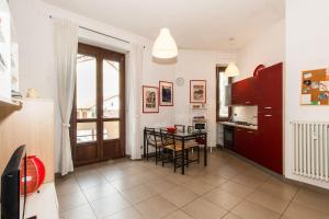 een keuken met rode kasten en een tafel met stoelen bij Mercato Centrale Colorful Flat in Turijn