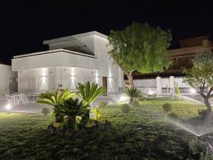 a large white house with a yard at night at Home Olympus Vesuvio in Pompei