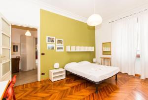 een slaapkamer met een bed en een groene muur bij Mercato Centrale Colorful Flat in Turijn