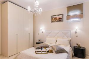 a bedroom with a white bed and a chandelier at Faidra Luxury Apartment in Flóka
