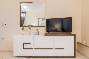 a white cabinet with a television on top of it at Faidra Luxury Apartment in Flóka +5 photos