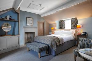 um quarto com uma cama king-size e uma lareira em Devonshire Arms at Beeley - Chatsworth em Beeley