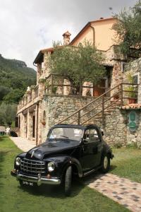 een zwarte auto geparkeerd voor een gebouw bij L'Allegra Brigata in Finale Ligure