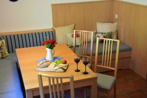 a table with two chairs and a table with wine glasses at Haus Mortna in Liesing