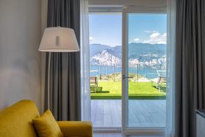 sala de estar con una puerta corredera de cristal que da a un balcón en Pinini Country Apartments, en Malcesine