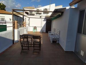 eine Terrasse mit einem Tisch und Stühlen auf einem Gebäude in der Unterkunft Casa Pedro Páez in Belmonte