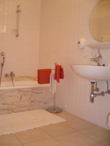 een badkamer met een bad, een wastafel en een toilet bij Hotel Ambassade in Waregem