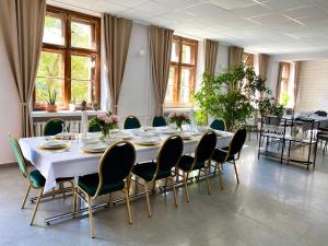 a dining room with a white table and chairs at Hotel Azyl in Gorzów Wielkopolski