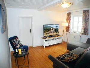 sala de estar con sofá y TV de pantalla plana en Ferienwohnung Gretel en Kassel