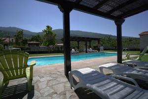 eine Gruppe von Liegestühlen und einem Pool in der Unterkunft La Cañada del Valle del Jerte in Navaconcejo