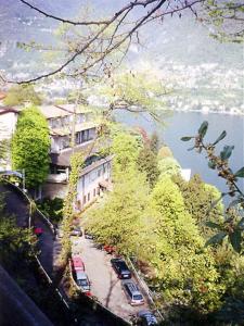 a building with cars parked on a street next to a lake at Hotel Glavjc in Torno