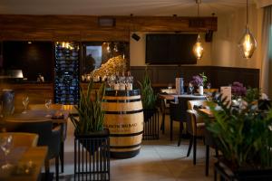 a restaurant with tables and chairs and a wine barrel at Hotel & Restauracja Gniecki in Hrubieszów