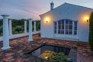 a house with a pond in front of it at Monte das Sesmarias in Redondo